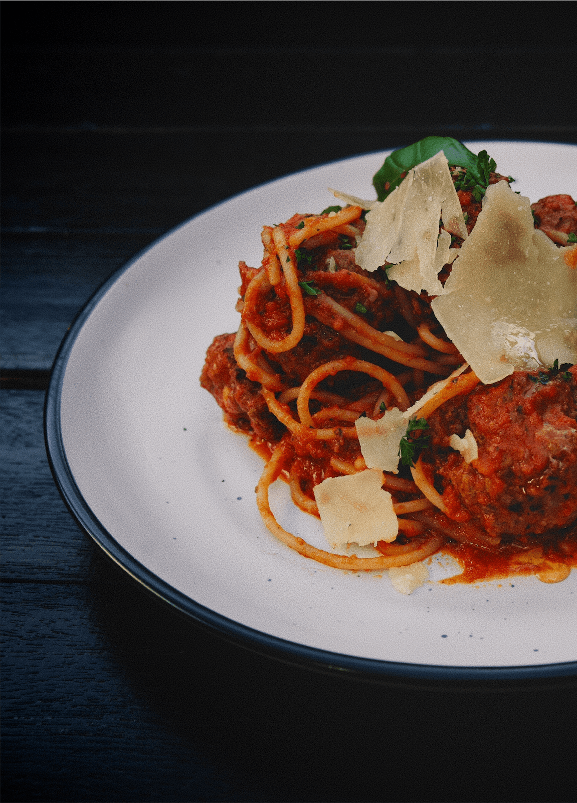 Spaghetti and meatballs with shaved parmesan and basil